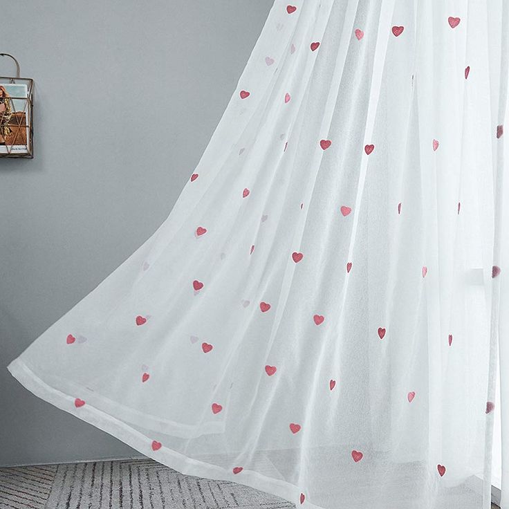 a white curtain with pink hearts on it