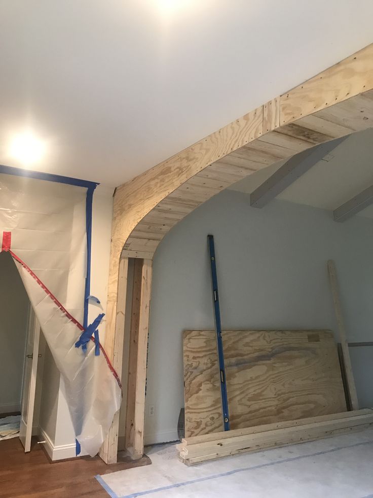 an unfinished room with wood being worked on the ceiling and walls, along with other construction materials