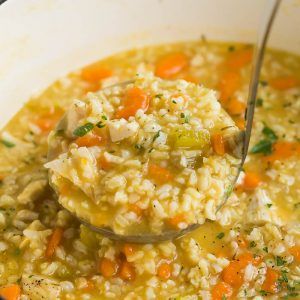 a ladle full of chicken and rice soup