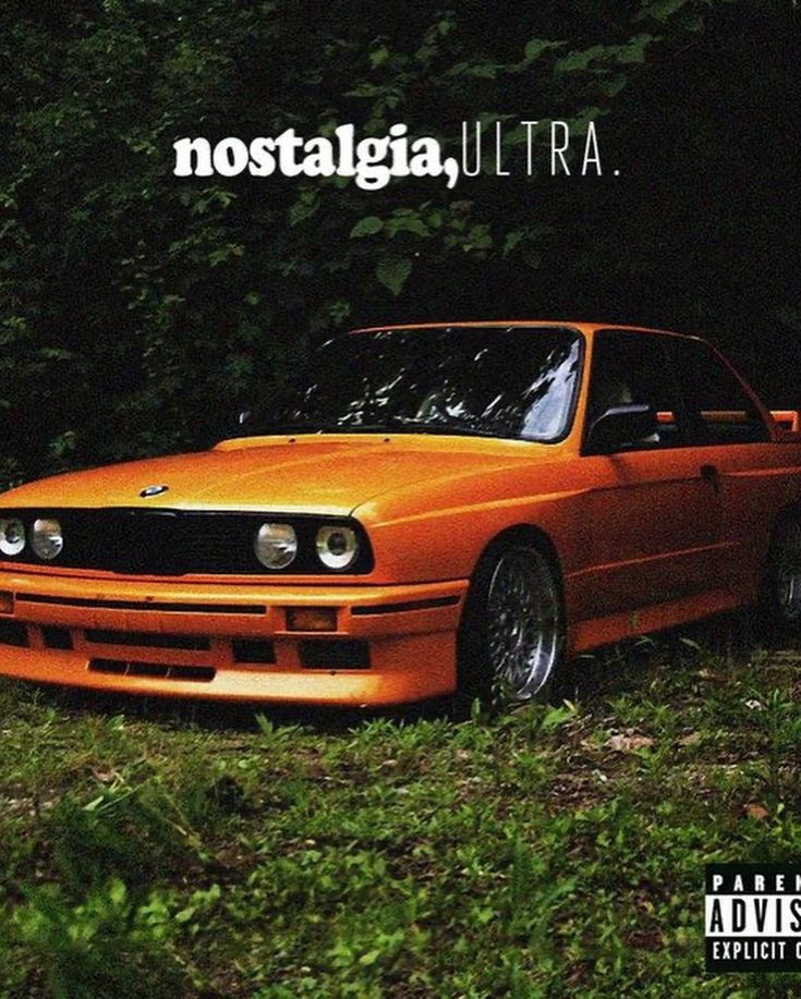 an orange car parked in the grass next to some trees and bushes with words nostalga, ultra