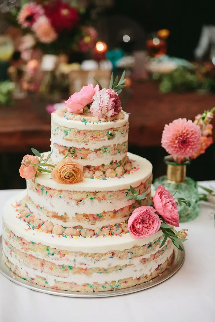 a wedding cake with flowers and sprinkles on it