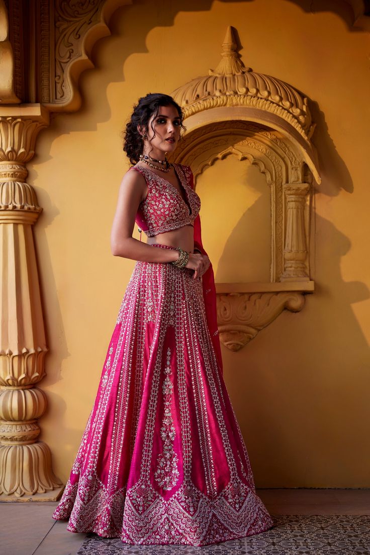 Pink raw silk flared skirt with intricate zardozi, kundan, glass beads and resham embroidery paired with deep v neckline raw silk embroidered blouse and organza dupatta with embroidered borders and zardozi and pearl buttis.From Chamee and Palak's The Romantics collection.DELIVERY TIMEPlease allow 8-12 weeks for your outfit to arrive.FABRIC DETAILSRaw Silk, OrganzaProfessional cleaning only. Semi-stitched Hand Embellished Lehenga For Navratri, Navratri Semi-stitched Hand Embellished Lehenga, Hand Embellished Lehenga For Navratri With Traditional Drape, Traditional Draped Hand Embellished Lehenga For Navratri, Hand Embellished Lehenga For Navratri, Navratri Semi-stitched Hand Embellished Choli, Navratri Hand Embellished Semi-stitched Choli, Festive Hand Embellished Saree Sets, Raw Silk Gown With Cutdana