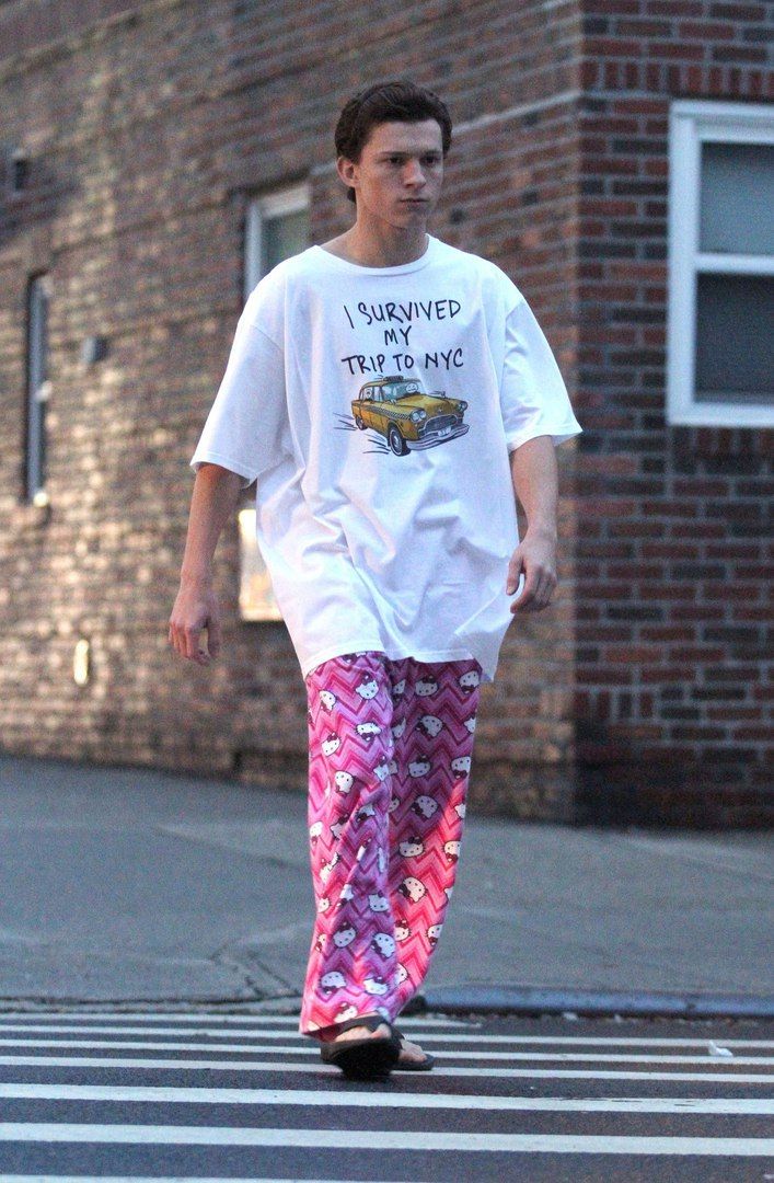 a man walking across a street while wearing pajamas