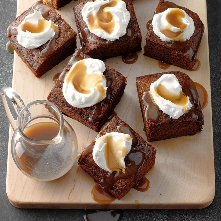 several pieces of brownies on a cutting board with caramel sauce and whipped cream