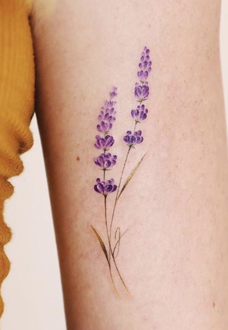 a close up of a person's leg with a tattoo on the side of her arm