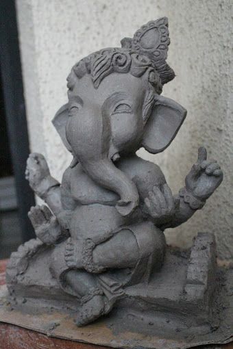 an elephant statue sitting on top of a wooden table next to a wall and door