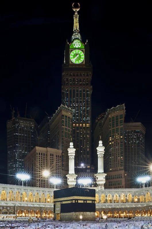 a large clock tower towering over a city at night