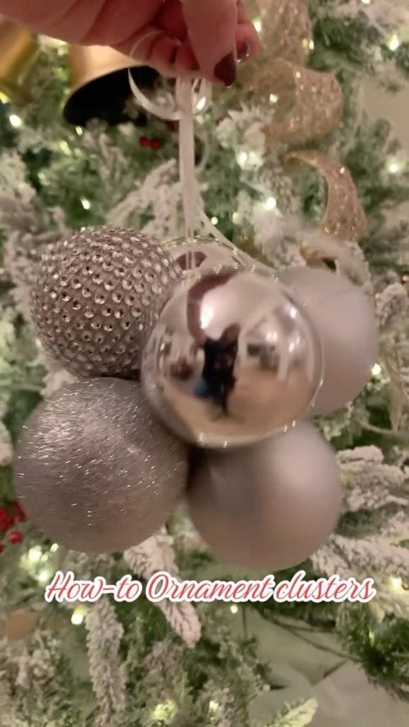 someone is decorating a christmas tree with silver bauble ornament balls