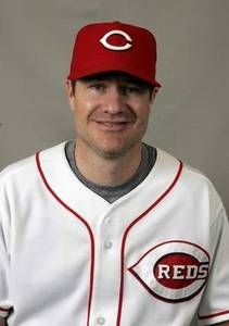 a man in a red and white baseball uniform posing for a photo with his hands on his hips