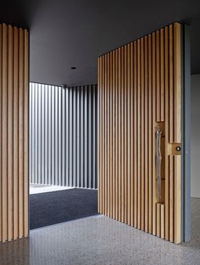 an open door with vertical slats on the outside and inside, leading into a room