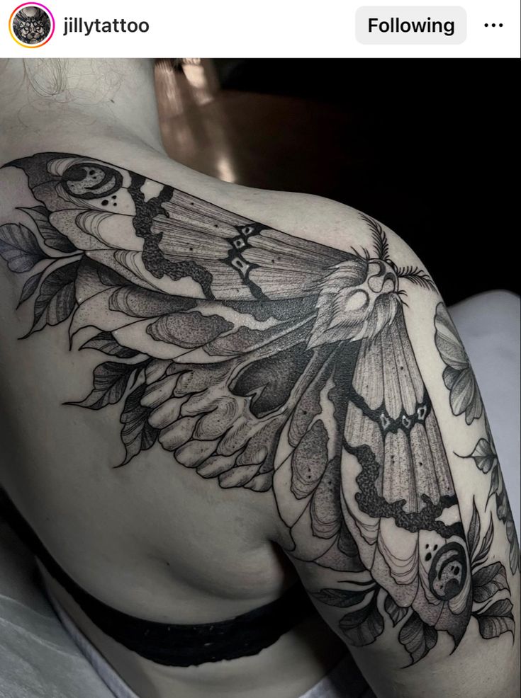 a black and white photo of a woman's shoulder with butterfly tattoos on it