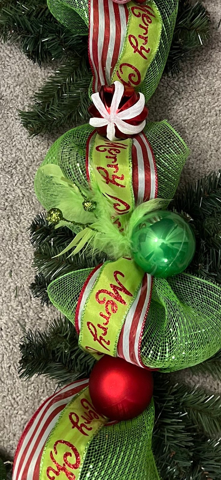 a christmas tree with green and red ribbons