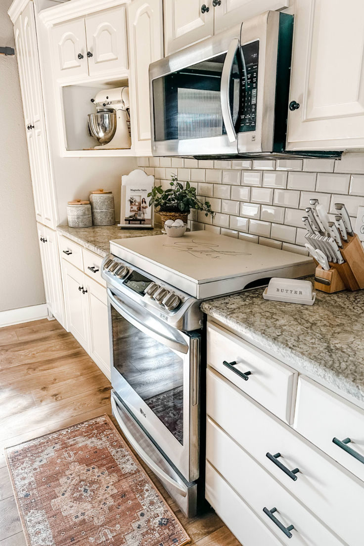 a kitchen with an oven, microwave and counter tops in white cabinets is pictured here