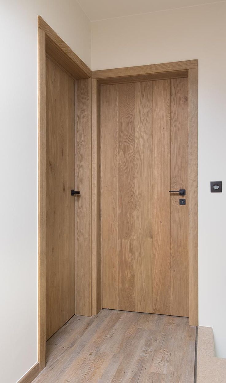 an empty room with wooden doors and wood flooring on either side of the door