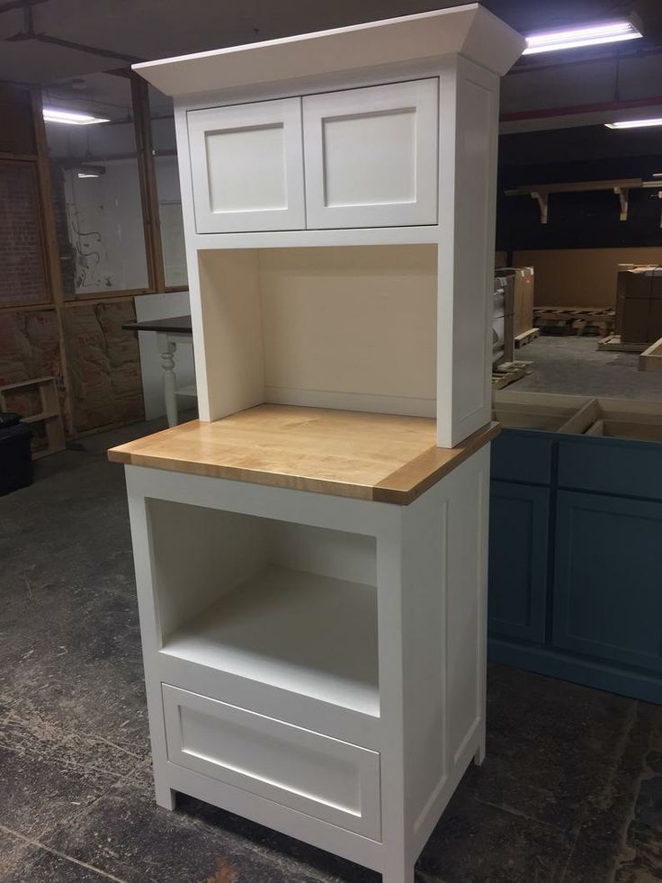 a white kitchen island with wooden top and drawers