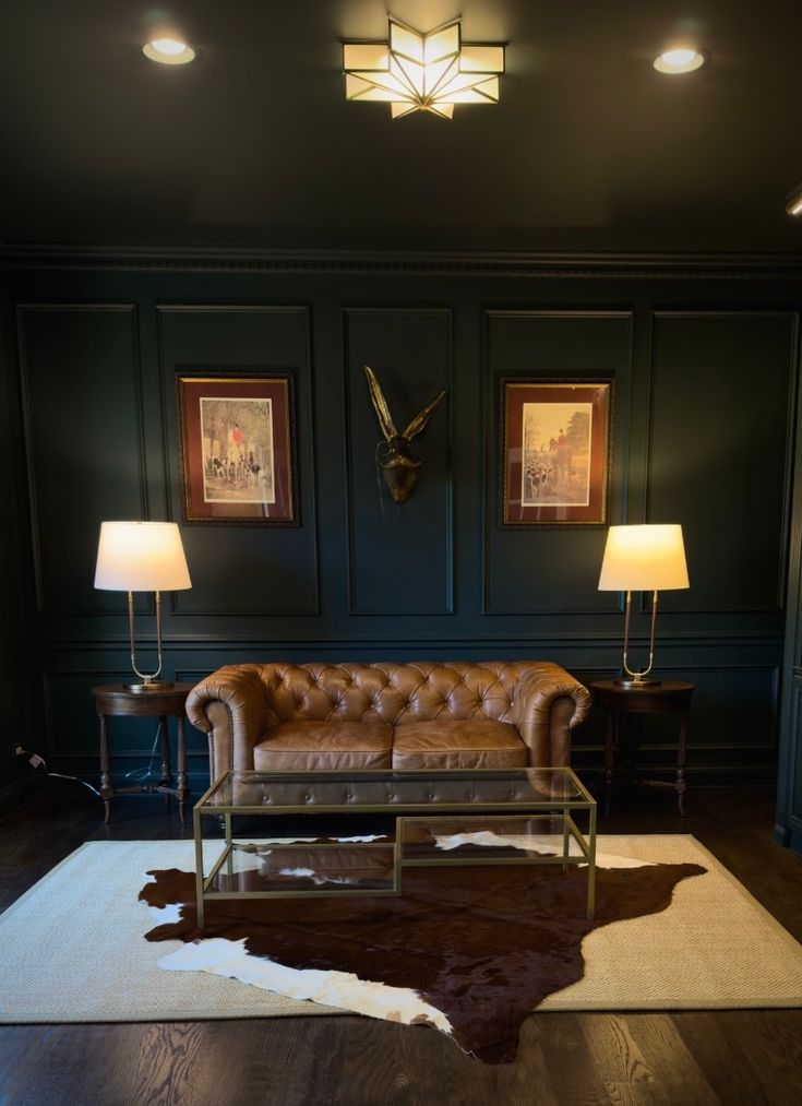 a brown leather couch sitting in a living room next to two lamps