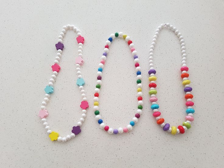 two necklaces made out of beads on a table