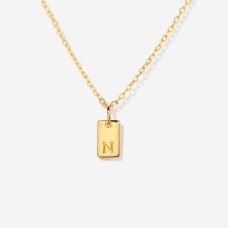 Embrace timeless elegance with this chic initial tag charm, a versatile piece designed to add a personal touch to any ensemble. Featuring a sleek, rectangular silhouette with a subtly embossed initial, this charm crafted from lustrous material is perfect for personalizing your favorite chain, bracelet, or accessory. Ideal for layering or as a standalone statement, this charm is a stylish way to keep a special initial close to your heart. Charm size: 10 mm x 5 mm Made of 14K gold over sterling si Silver Rectangular Initial Necklace, Elegant Silver Rectangular Initial Necklace, Classic Rectangular Jewelry For Personalized Gifts, Rectangular Initials Jewelry For Personalized Gift, Personalized Rectangular Initials Jewelry, Rectangular Charm Necklaces For Everyday, Classic Rectangular Jewelry For Everyday, Classic Rectangular Everyday Jewelry, Silver Engraved Initial Rectangular Necklace