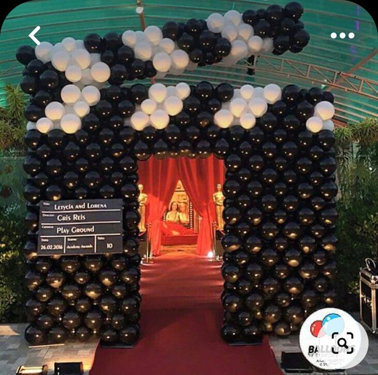 the entrance to an event with black and white balloons