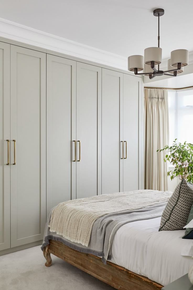 a bedroom with white walls and large closets in the corner, along with a bed that has two pillows on it