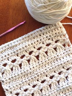 a ball of yarn sitting on top of a table next to a crochet doily