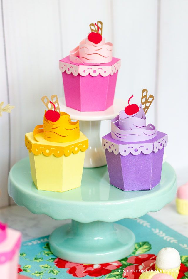 three colorful cupcakes are sitting on a table