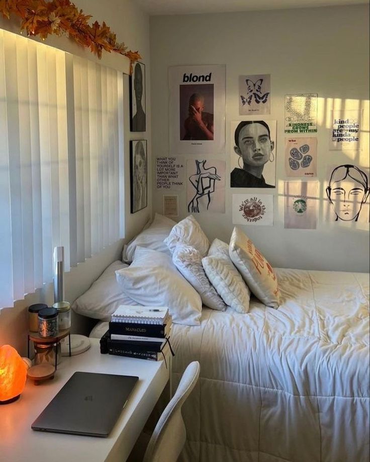 a white bed sitting under a window next to a laptop computer