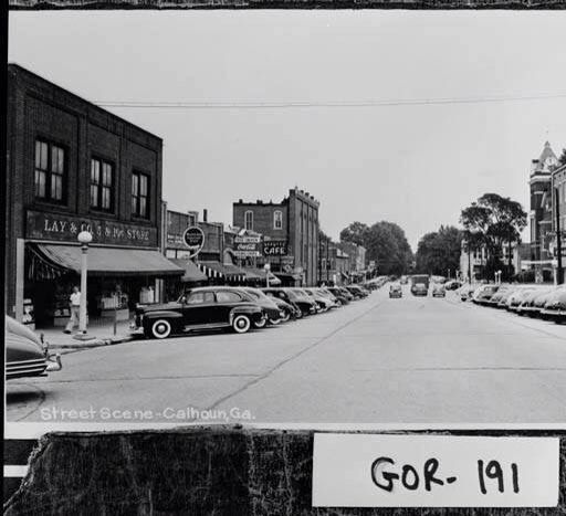 an old black and white photo of cars parked on the street