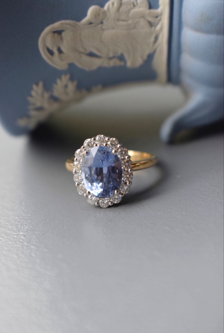 an oval shaped tan and white diamond ring with a blue topaz in the center