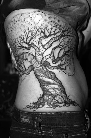 a woman with a tree tattoo on her stomach