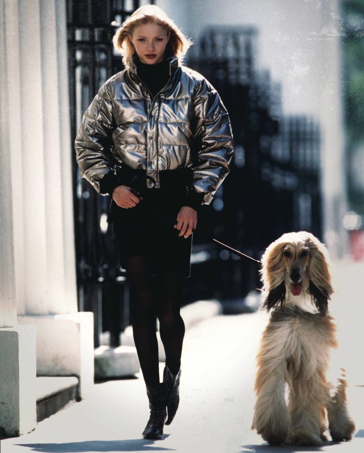 a woman walking her dog down the street