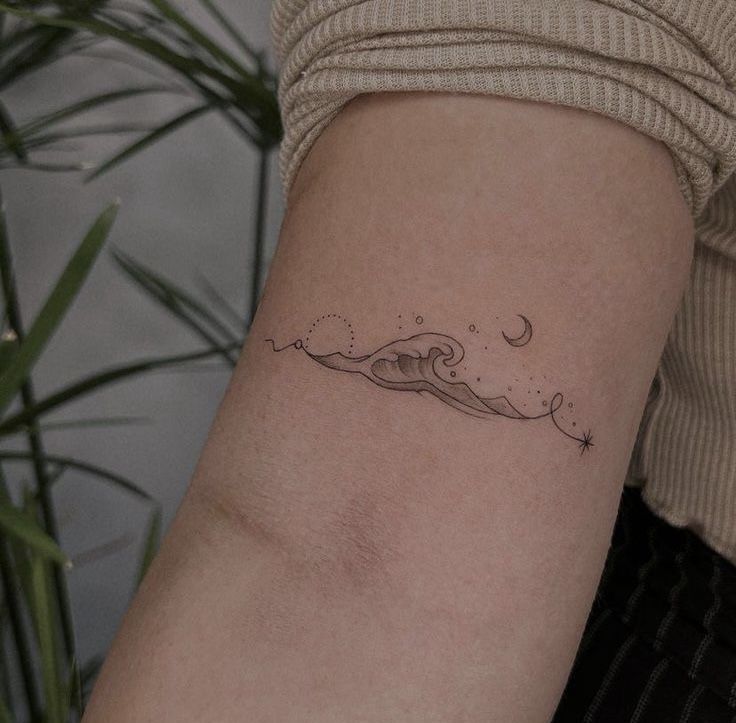 a woman's arm with a wave tattoo on the left side of her arm