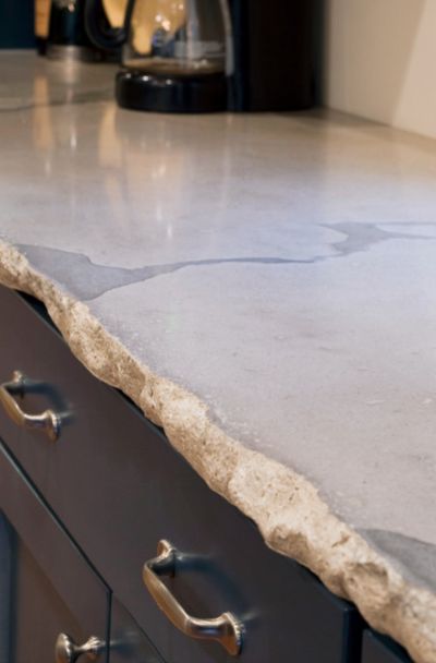 a kitchen counter top with two drawers and knobs on the bottom, in front of a coffee maker