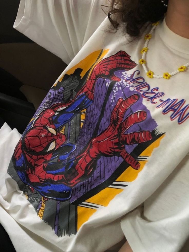 a person wearing a spider man shirt sitting down