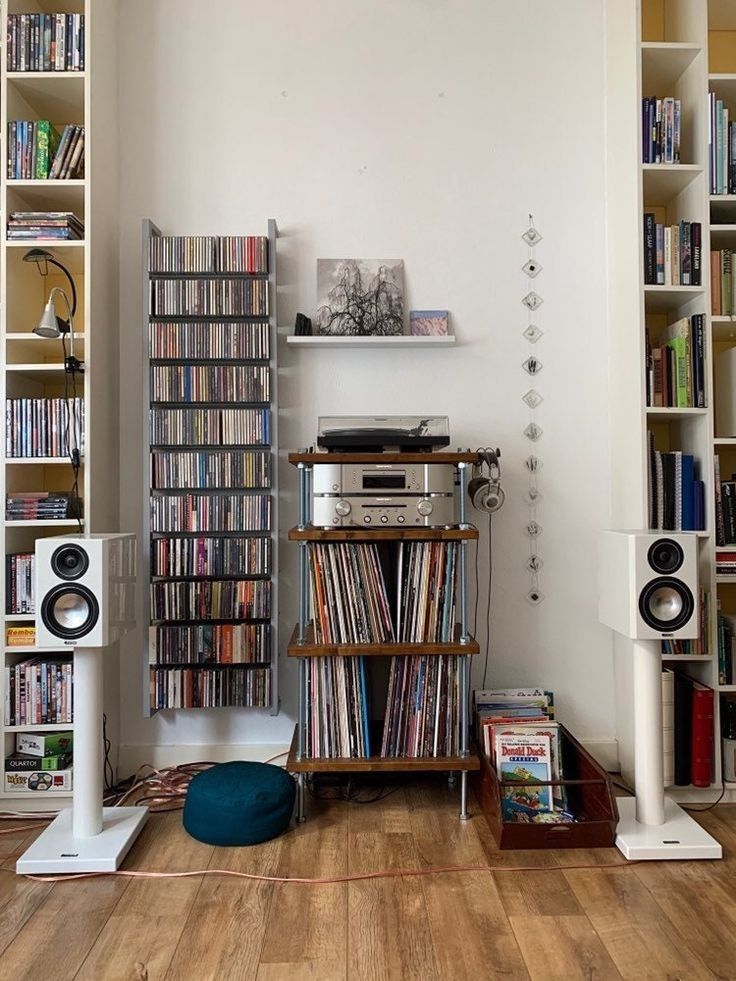 there is a record player in the corner of this room with many bookshelves