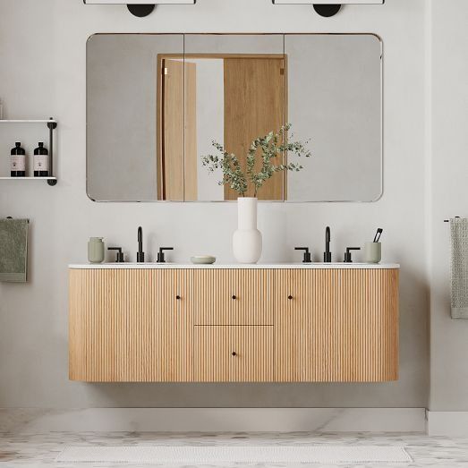 a bathroom with two sinks and a large mirror over the sink that is mounted to the wall