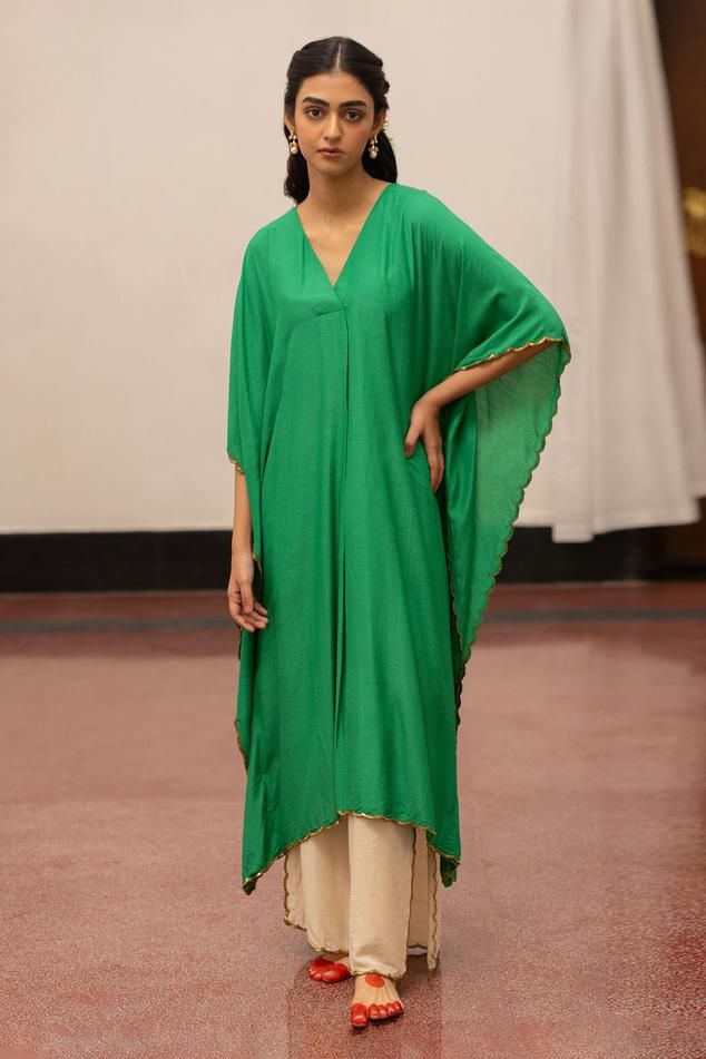 Emerald asymmetric kaftan, accentuated with sequins embroidered edges. Paired with a pant.
Components: 2
Pattern: Placement Embroidery
Type Of Work: Sequins
Neckline: V Neck
Sleeve Type: Three Quarter Sleeves
Fabric: Munga Silk: Kafta and Organza Silk: Pant
Color: Green
Other Details: 
Model height: 5ft 7inches, wearing size S
Length: 47 inches
Occasion: Puja - Aza Fashions Placement Embroidery, Coord Sets, Silk Pant, Silk Kaftan, Green Sequins, Silk Pants, Three Quarter Sleeves, Quarter Sleeve, Aza Fashion