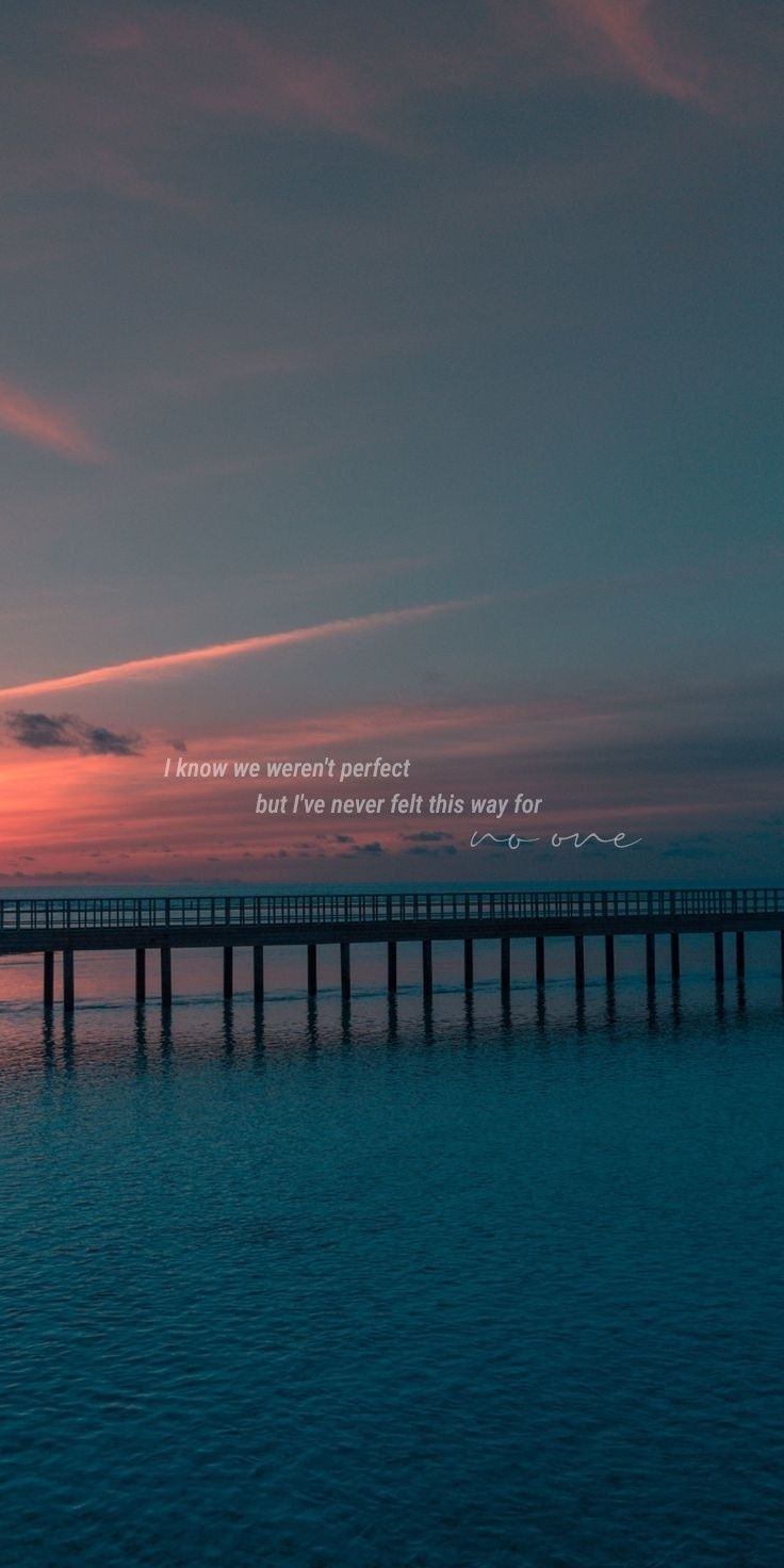 the sun is setting over the ocean with a pier in the foreground and an inspirational quote above it