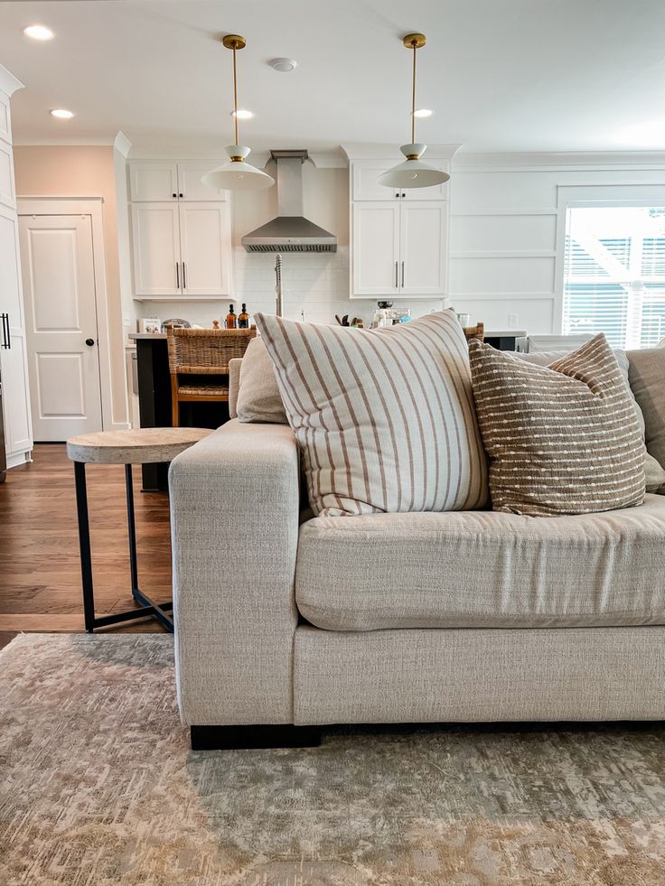 a living room filled with furniture next to a kitchen