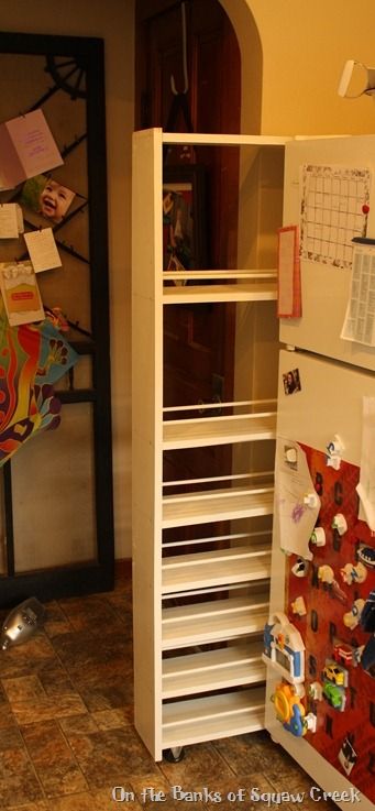 a white refrigerator freezer sitting inside of a kitchen next to a wall with magnets on it