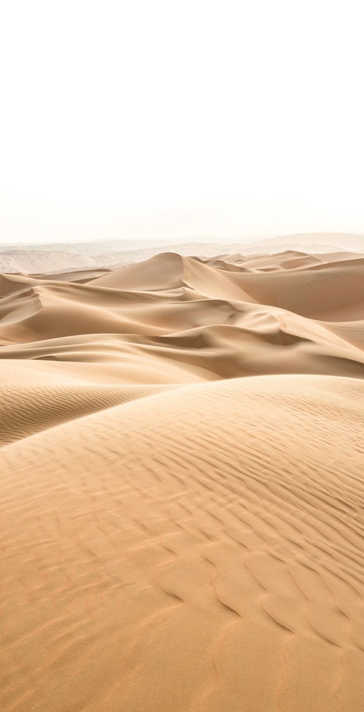 a person riding a horse in the middle of sand dunes, with no people on it