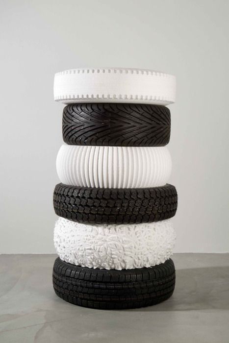 a stack of tires sitting on top of each other in front of a white wall