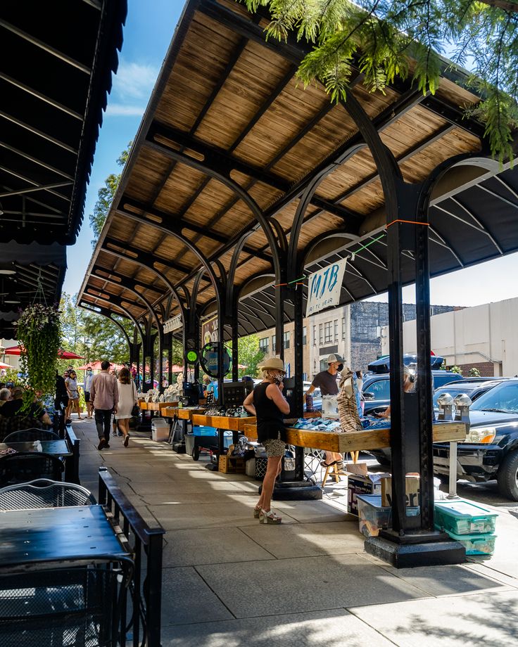 people are standing under an awning on the sidewalk