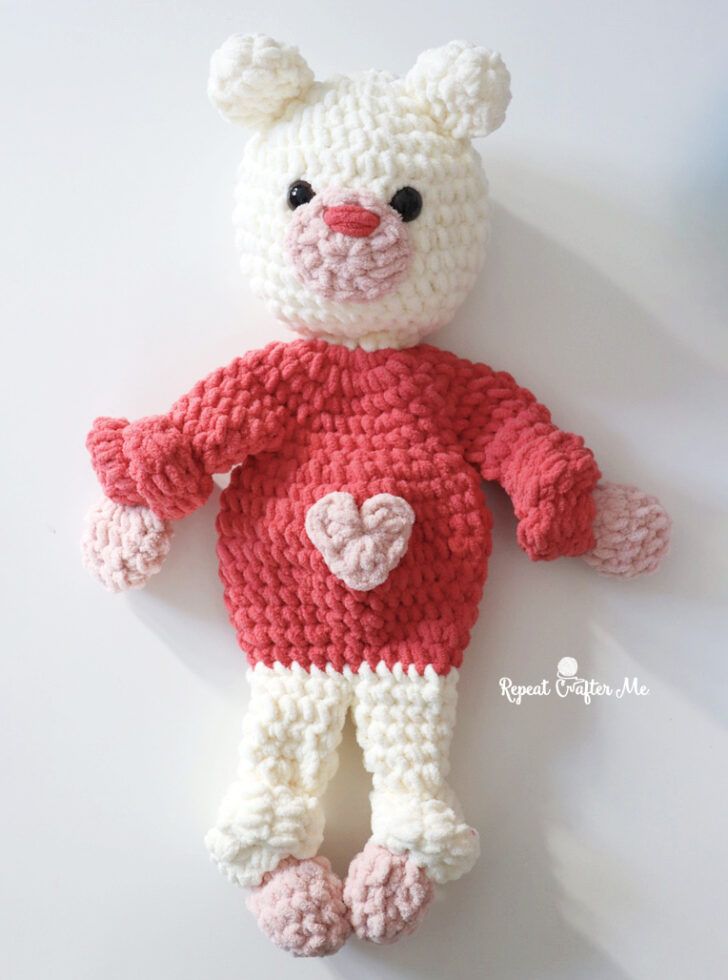 a crocheted teddy bear with a heart on it's chest and legs