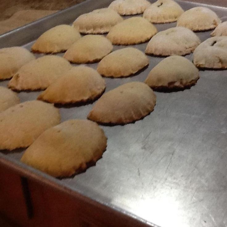 freshly baked pastries are lined up on a baking sheet in an oven, ready to go into the oven