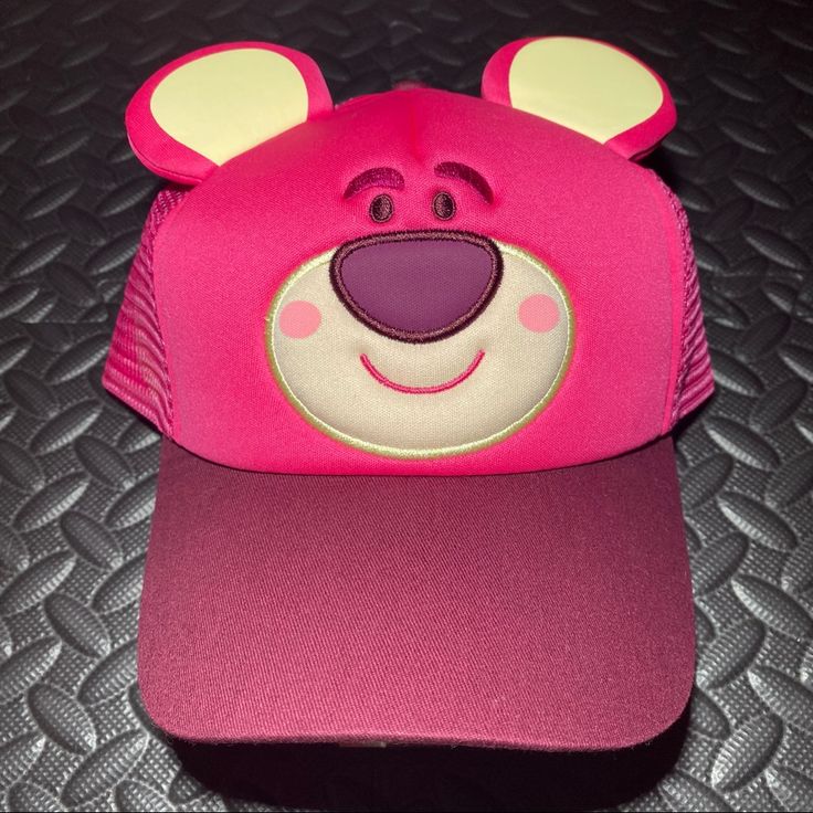 a pink hat with a bear face on it