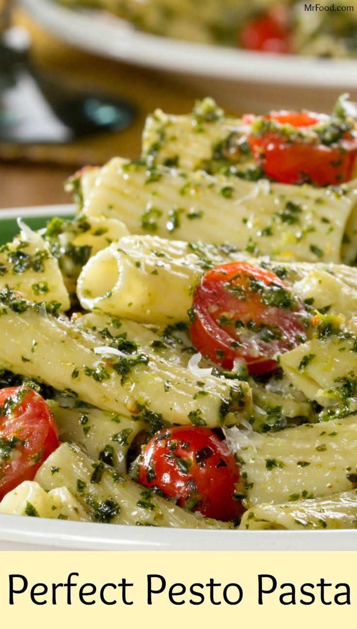 pasta with pesto and tomatoes in a white bowl