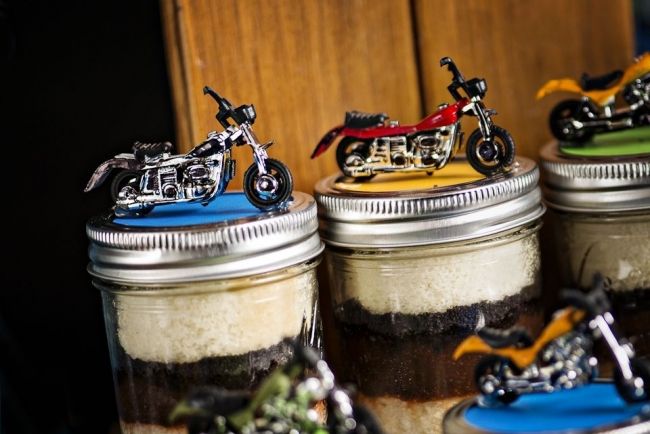 three mason jars filled with dirt bikes on top of a table