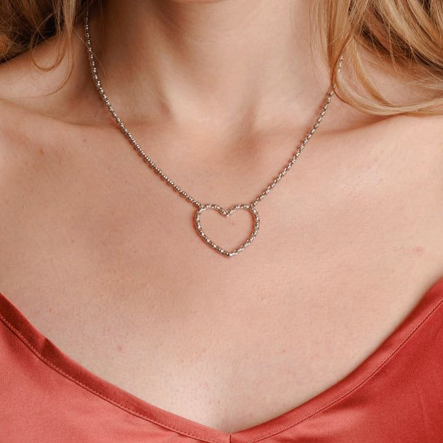 Translated from Italian, ‘Amore’ means love, and it’s a sentiment that we always like to express through beautiful, handcrafted pieces. The Amore Collection features a heart shape entirely crafted from our signature Links chain in 2mm diameter. Refined and romantic, these pieces are timeless symbols of love and romance. ​​The iconic DelBrenna texture makes them fresh and original. The Amore necklace is an ideal gift for someone special in your life, or just for yourself, representing your unique Valentine's Day White Gold Heart Necklace With Chain, Heart Shaped Cable Chain Necklace For Anniversary, Feminine Heart Pendant Necklace For Valentine's Day, Anniversary Necklaces With Heart Detail, Heart Necklace With Cable Chain For Anniversary, Silver Heart Necklace Feminine Style, Feminine Silver Heart Necklace, Feminine Heart-shaped Necklace For Anniversary, Feminine Heart-shaped Anniversary Necklaces