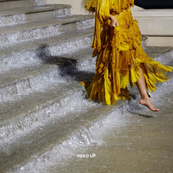 a woman in a yellow dress walking down some steps